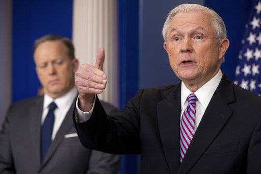 Attorney General Jeff Sessions, right, accompanied by White House press secretary Sean Spicer, left, talks to the media during the daily press briefing at the White House, Monday, March 27, 2017, in Washington. (AP Photo/Andrew Harnik)
