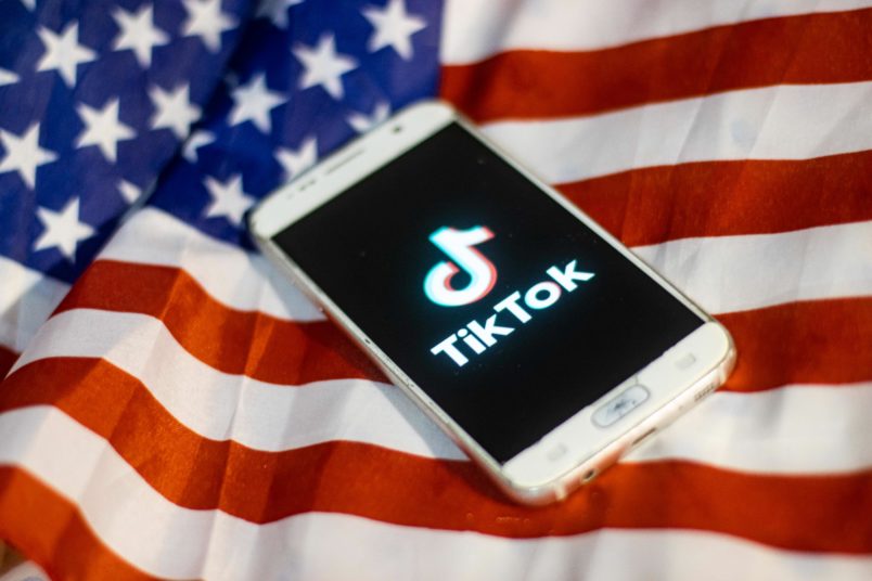 TikTok closeup logo displayed on a phone screen, smartphone on the American flag or U.S. flag, the national flag of the United States are seen in this multiple exposure illustration. Tik Tok is a Chinese video-sharing social networking service owned by a Beijing based internet technology company, ByteDance. It is used to create short dance, lip-sync, comedy and talent videos. ByteDance launched TikTok app for iOS and Android in 2017 and earlier in September 2016 Douyin fror the market in China. TikTok became the most downloaded app in the US in October 2018. President of the USA Donald Trump is threatening and planning to ban the popular video sharing app TikTok from the US because of the security risk. On August 3, 2020 in Thessaloniki, Greece.(Photo by Nicolas Economou/NurPhoto)