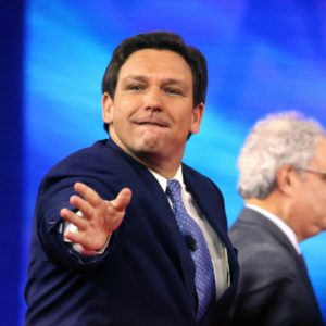 Florida Gov. Ron DeSantis tosses hats into the crowd as he takes the stage at the 2022 CPAC conference at the Rosen Shingle Creek in Orlando, Florida, on Thursday, Feb. 24, 2022. (Joe Burbank/Orlando Sentinel/Tribune News Service via Getty Images)